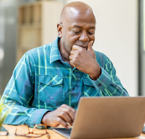 Man looking at his laptop with a questionable look on his face