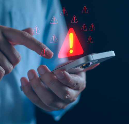 Person clicking phone with warning signs showing